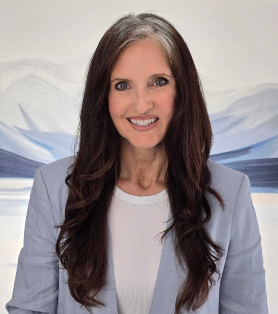 Headshot of Kimberley Black smiling directly towards the camera and wearing a white t-shirt under a light blue blazer.